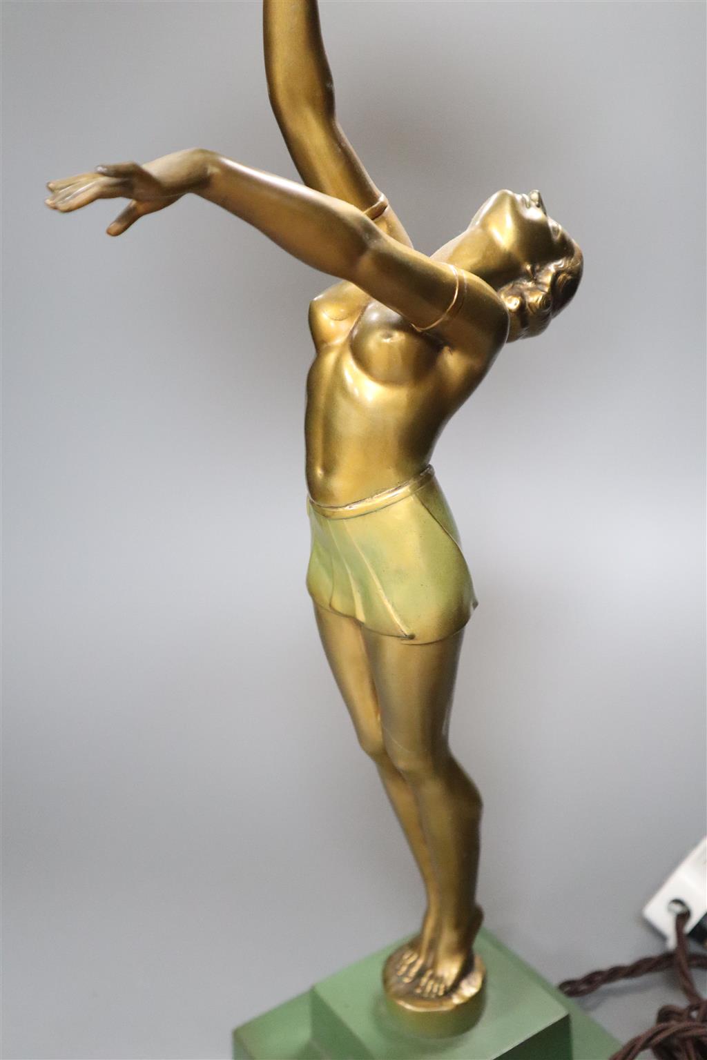 An Art Deco spelter figural table lamp, with semi-nude dancer holding a glass shade aloft, 64cm overall